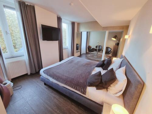a bedroom with a large bed with pillows at Saillant Hotel Maastricht City Centre - Auping Hotel Partner in Maastricht