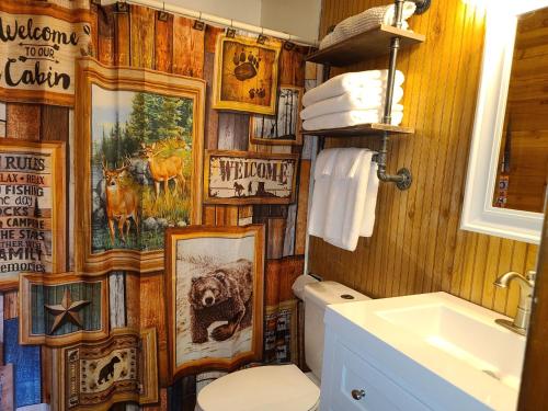 a bathroom with a wooden wall with pictures on it at The White Stag in Hillsboro