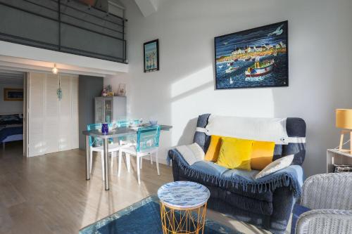 un salon avec un canapé et une table dans l'établissement Ti Roz - Vue mer, à Perros-Guirec