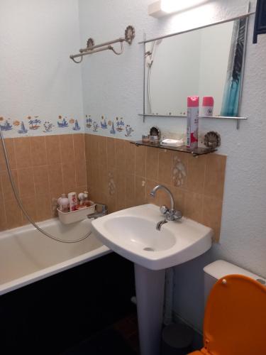 une salle de bain avec un lavabo, une baignoire et un miroir dans l'établissement Cap Agde studio rénové piscine, au Cap d'Agde