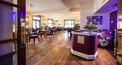セント・ヘリア・ジャージーにあるBest Western Royal Hotelのテーブルと椅子のあるバー付きのレストラン