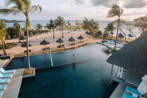 a woman standing in a swimming pool at a resort at Radisson Blu Azuri Resort & Spa in Roches Noires