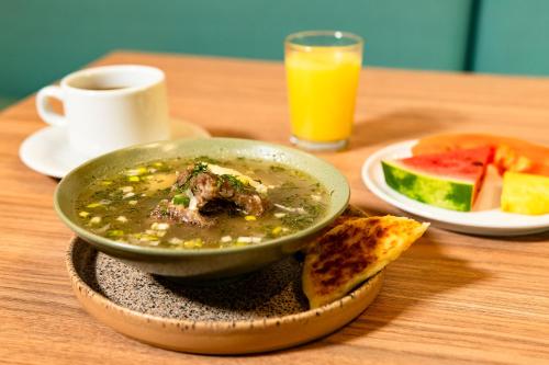 een kom soep op een tafel met een bord eten bij Hotel Rilux Cartagena in Cartagena