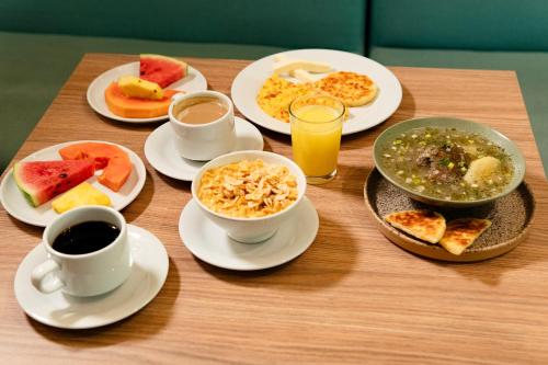 een tafel met borden eten en kopjes koffie bij Hotel Rilux Cartagena in Cartagena