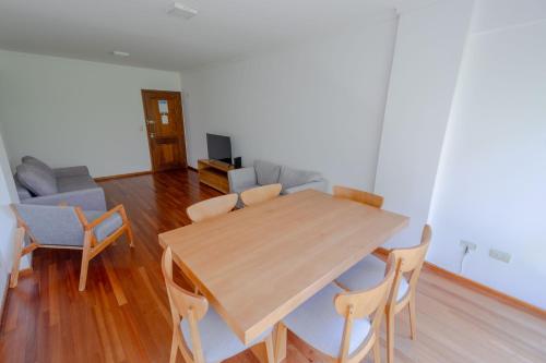 un soggiorno con tavolo e sedie in legno di Check and Home - Córdoba - Departamento Moderno en el Centro al Frente con Cochera a Mar del Plata