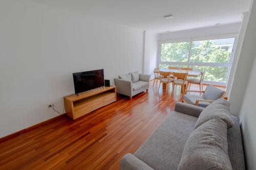 un soggiorno con un divano, una TV e un tavolo di Check and Home - Córdoba - Departamento Moderno en el Centro al Frente con Cochera a Mar del Plata