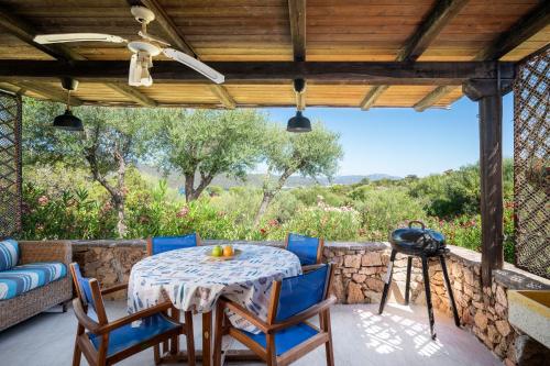 a patio with a table and chairs and a couch at Caletta Nest 88 in Porto Rotondo