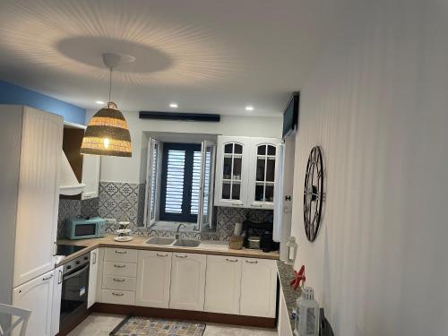a kitchen with white cabinets and a ceiling at Casa 99 in Amendolara