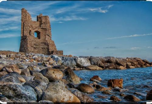an old building on the rocks near the water at Casa 99 in Amendolara