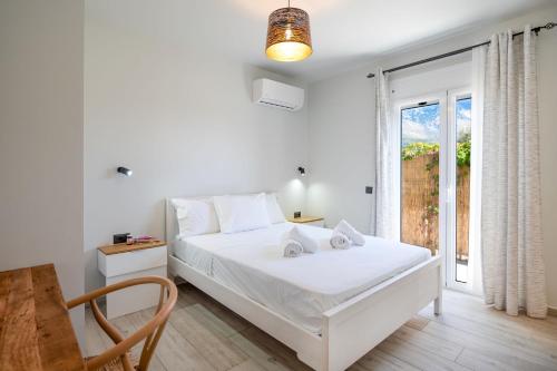 una camera da letto bianca con un letto e una finestra di Villa Katerina Mentoros a Karavádhos