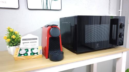 a microwave oven sitting on a shelf next to a box at Apartment near Central Festival Hatyai in Hat Yai