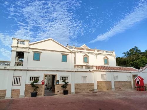 a white building with a blue sky in the background at 八八金歐王金城洋樓古厝民宿 in Jinsha