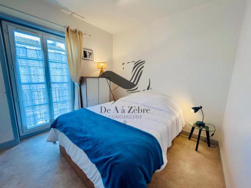 une chambre avec un lit et une grande fenêtre dans l'établissement L'Albatros - Situé en plein coeur de ville, à Rochefort