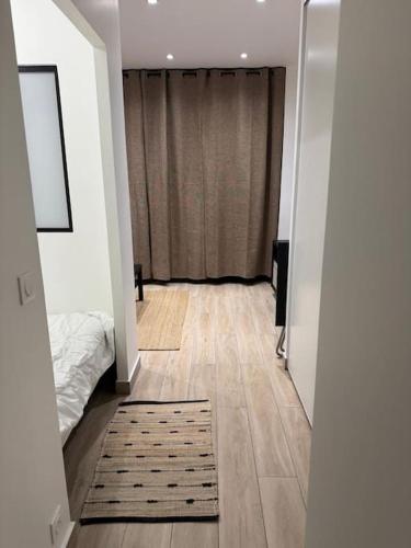 - un couloir avec un lit et un tapis au sol dans l'établissement studio porte de paris-Saint-Ouen - Emile Zola, à Saint-Ouen