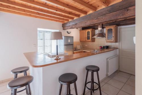 una cocina con 3 taburetes de barra en Maison Anthian, en Arcizans-Avant