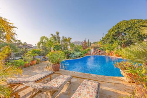 a swimming pool with two lounge chairs and a swimming pool at Sconto in L'Alfas del Pi