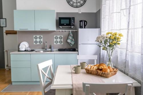 eine Küche mit blauen Schränken und einem Tisch mit einem Korb Brot in der Unterkunft Spacious Studio Close to City Center l Washing Machine l Kitchen in Novi Sad