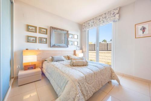 a bedroom with a bed and a large window at Sconto in L'Alfas del Pi