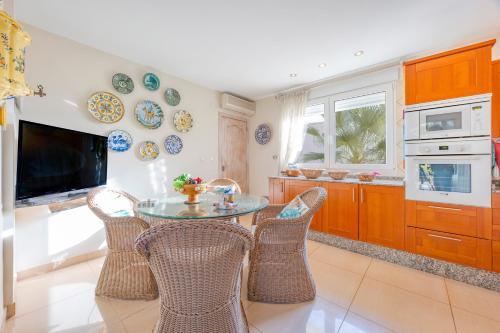 a kitchen with a table and chairs and a tv at Sconto in L'Alfas del Pi