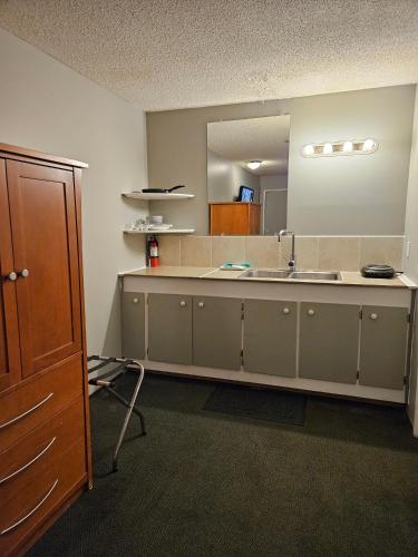 a bathroom with a sink and a large mirror at King's Motel & Restaurant in St. Paul