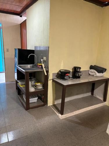 a kitchen with a table and a sink in a room at Natural Manzanillo in Manzanillo