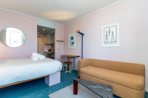 a hotel room with a bed and a couch at The Tropicana Hotel in Cape Town