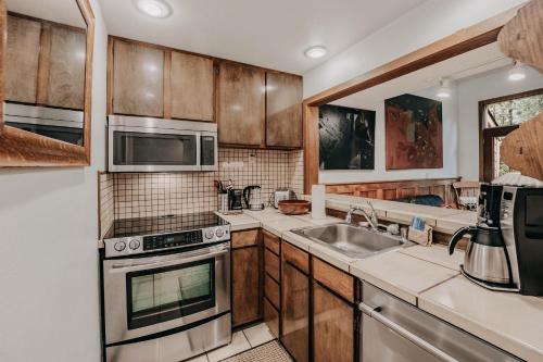 a kitchen with wooden cabinets and stainless steel appliances at Snowater Condo 57 - A Great 2-Story Family Condo That Sleeps 6 in Glacier