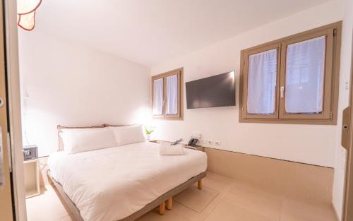 a bedroom with a white bed and two windows at Ca' La Stampa in Venice