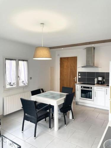 une cuisine avec une table et des chaises dans une pièce dans l'établissement Appartement T2 lumineux, très bien équipé, proche centre-ville, à Salies-de-Béarn