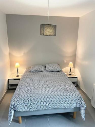- une chambre avec un lit, 2 tables de chevet et 2 lampes dans l'établissement Appartement T2 lumineux, très bien équipé, proche centre-ville, à Salies-de-Béarn
