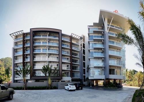a large building with cars parked in front of it at AtKaronWithChadaB311 in Karon Beach