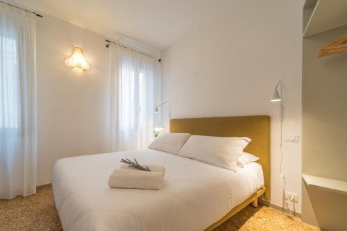 a bedroom with a white bed and a window at Ca' La Stampa in Venice