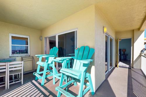 a patio with blue chairs and a table on a balcony at Anglers Cove 602 in St. Pete Beach