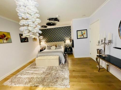 a bedroom with a bed and a chandelier at Luxury City Center apartment with Canal view 1 kingsize bed and 1 sleeping sofa in Amsterdam