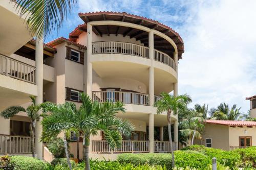 a building with palm trees in front of it at Residences at Barrier Reef 8C Oceanview 2 BR by Stay Floreo in San Pedro