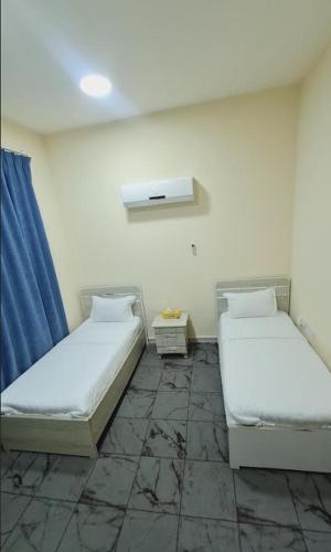 a room with two beds in a room at Evan إيفان in Salalah
