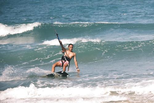 a woman is standing on a surfboard in the ocean at EasyLife Villa Hoi An in Tân Thành (1)
