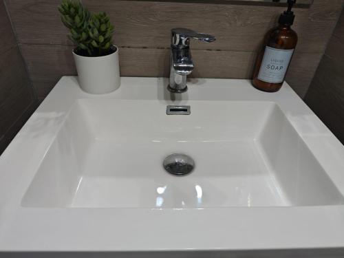 a white bathroom sink with a bottle of wine at Depa con piscina frente al Lago Llanquihue y vista al volcán in Puerto Varas