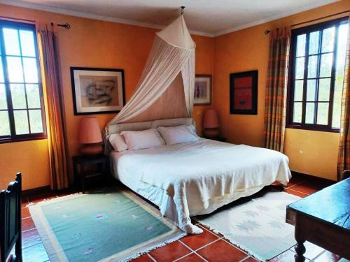 a bedroom with a bed with a canopy at Casa da Lagoa BB or HB options in Santana