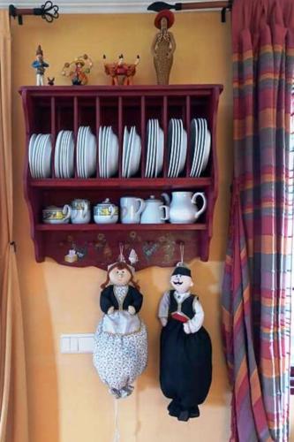 two figurines on a wall with a shelf with dishes at Casa da Lagoa BB or HB options in Santana