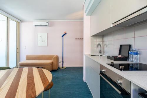 a kitchen with a table and a couch in a room at The Tropicana Hotel in Cape Town