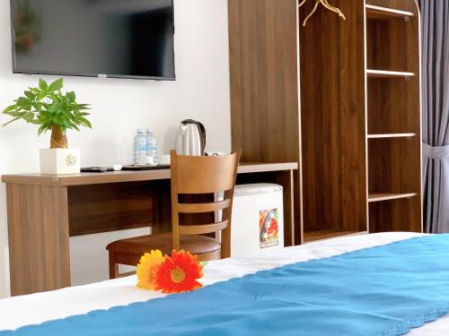 a bedroom with a desk and a bed with a flower on it at EasyLife Villa Hoi An in Tân Thành (1)