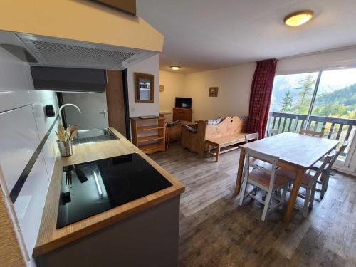une cuisine et un salon avec une table et une salle à manger dans l'établissement Appartement 3 Pièces + Cabine 8/10 Pers. - Cœur de Station, Proche Pistes et Commerces, 55m² - FR-1-265-191, à Valfréjus