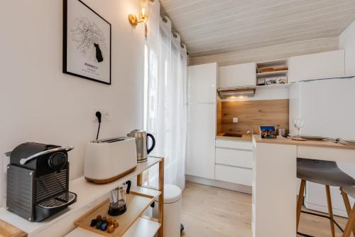 Elle comprend une petite cuisine avec des placards blancs et un bureau. dans l'établissement Studio Mont Blanc - pour 2 personnes, à Annecy