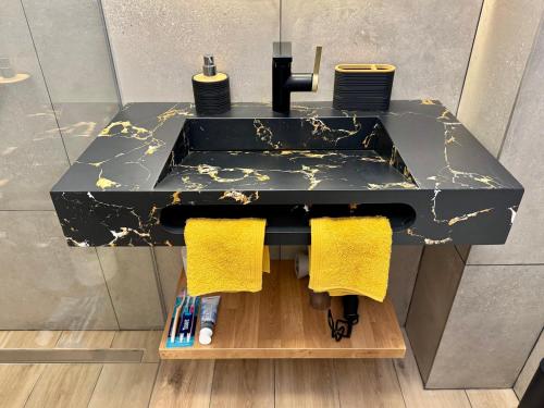 a bathroom sink with yellow towels on a counter at PaulMarie Olympia Studio in Playa de las Americas