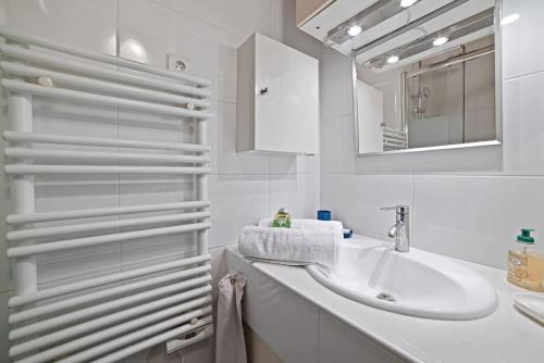une salle de bain blanche avec un lavabo et un miroir dans l'établissement Artistic apartment in Paris 12, à Paris