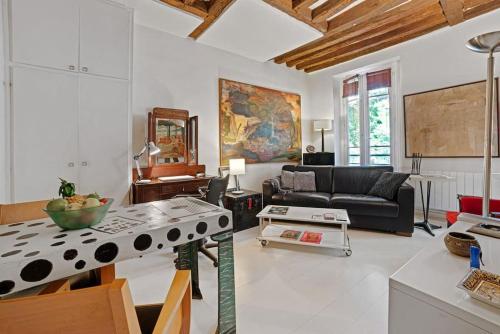 un salon avec un canapé et une table dans l'établissement Artistic apartment in Paris 12, à Paris