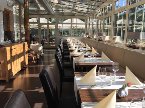 a row of tables in a restaurant with windows at Hotel Rezidence Golf in Mariánské Lázně