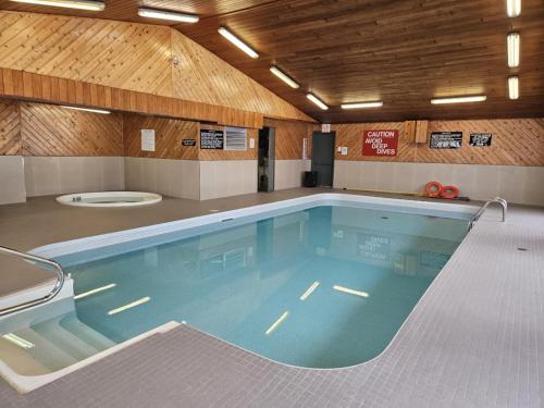 a large swimming pool in a building with a wooden ceiling at Travelodge by Wyndham Port Elgin in Port Elgin