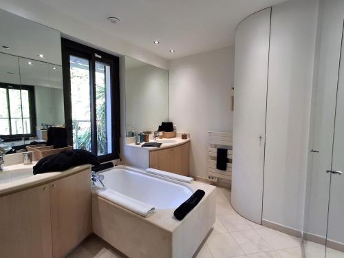 une grande salle de bain avec une baignoire et un lavabo dans l'établissement Villa Caribbean, à Cannes